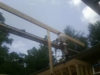 Carpenter setting a ridge beam over a new addition frame — Ice Dam Removal by Roofing Brothers in Alfred