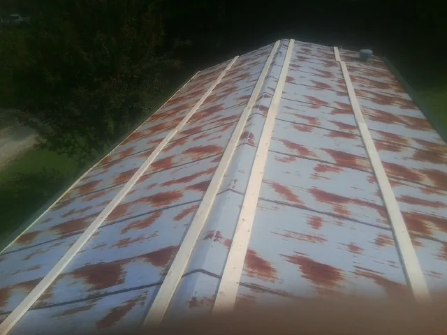 Rusted metal roof panels with new wood purlins before replacement — Storm Damage Roof Repair in Alfred by Roofing Brothers